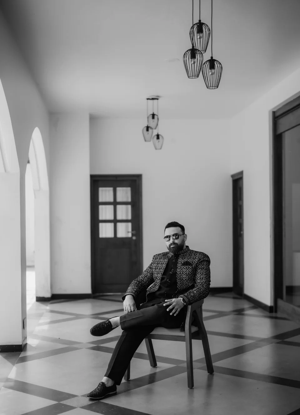 Gokul seated in a light-filled hallway, in a black-and-white portrait